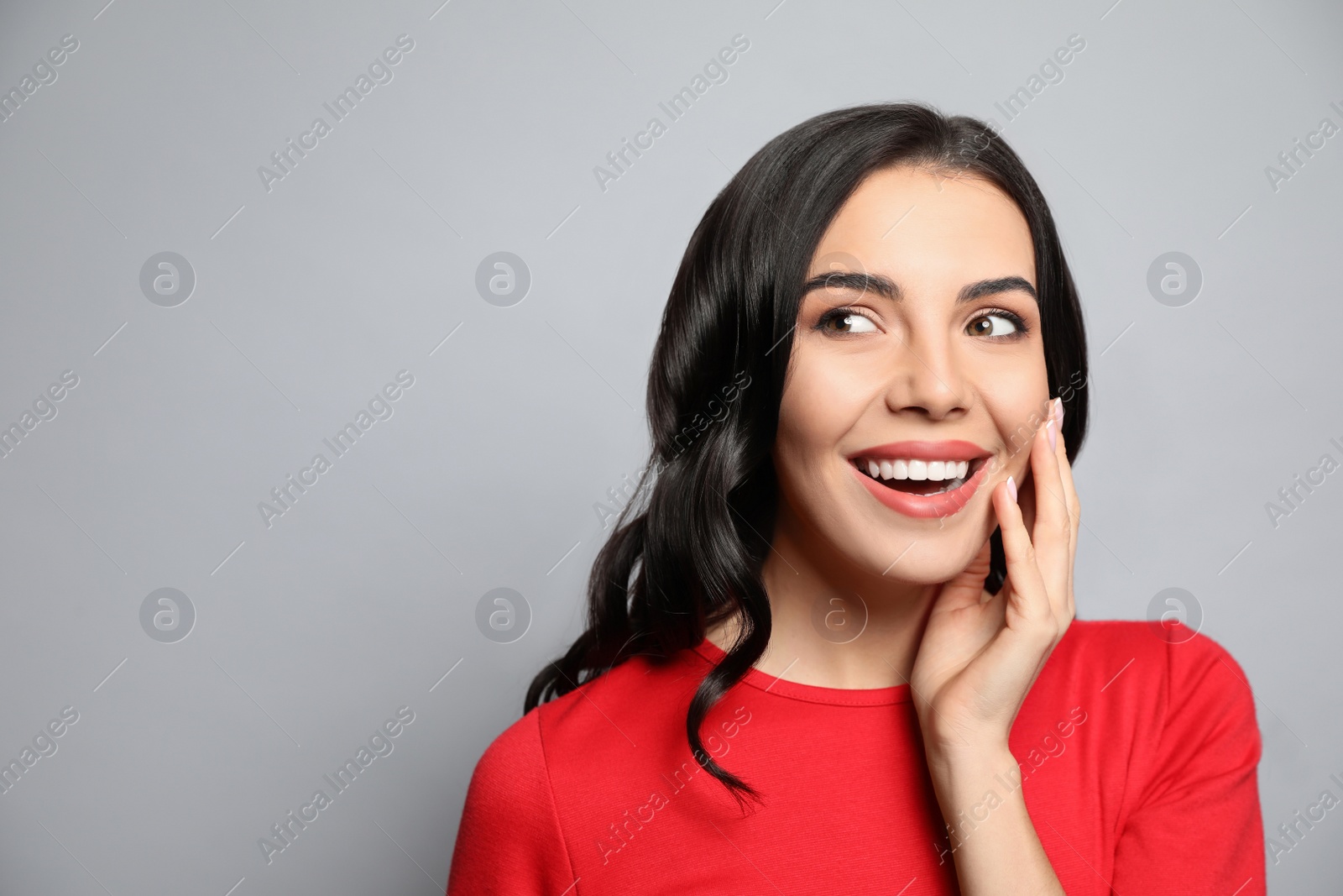 Photo of Portrait of surprised woman on grey background, space for text