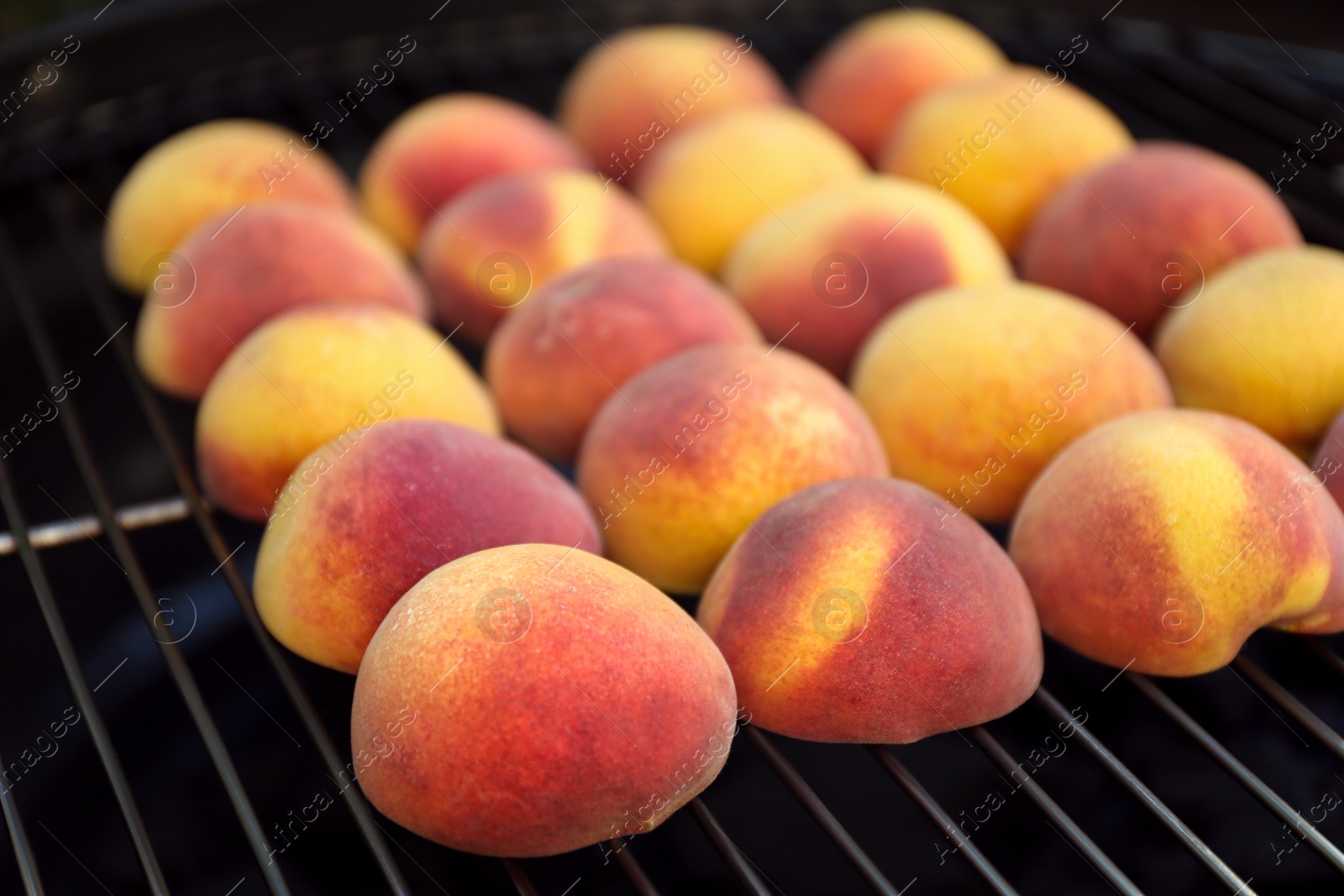 Photo of Modern grill with tasty juicy peaches, closeup