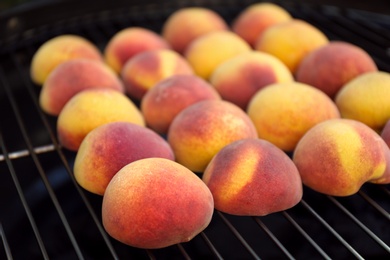 Photo of Modern grill with tasty juicy peaches, closeup