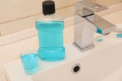 Photo of Mouthwash near tap on sink in bathroom. Teeth and oral care