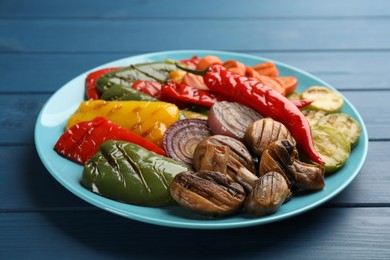 Photo of Delicious grilled vegetables on blue wooden table, closeup