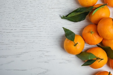 Photo of Fresh ripe tangerines and space for text on wooden background, top view