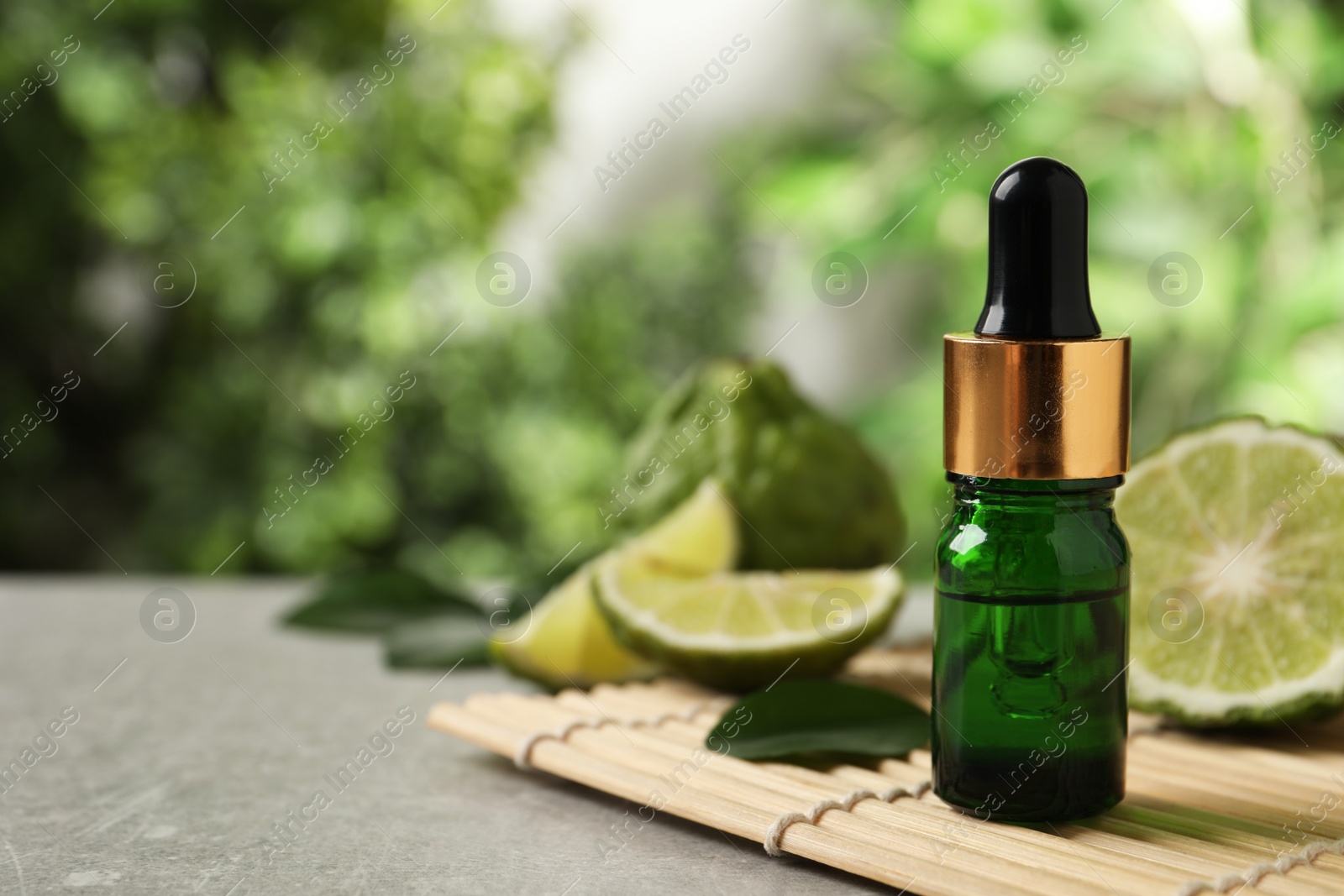 Photo of Glass bottle of bergamot essential oil on light table. Space for text