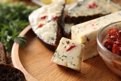 Photo of Tasty butter with dill and chili pepper on wooden plate, closeup