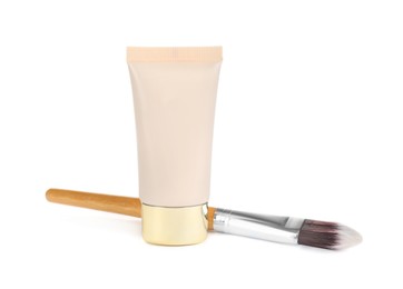 Photo of Tube of skin foundation and brush isolated on white. Makeup product