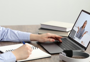 Image of E-learning. Woman having online lesson with teacher via laptop at home, closeup