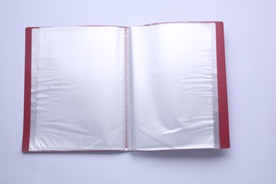 Photo of File folder with punched pockets and paper sheets isolated on white, top view