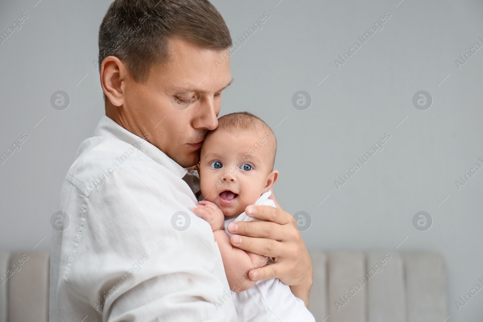 Photo of Father holding his cute baby at home, space for text