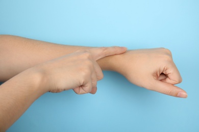 Woman showing word time on color background, closeup. Sign language