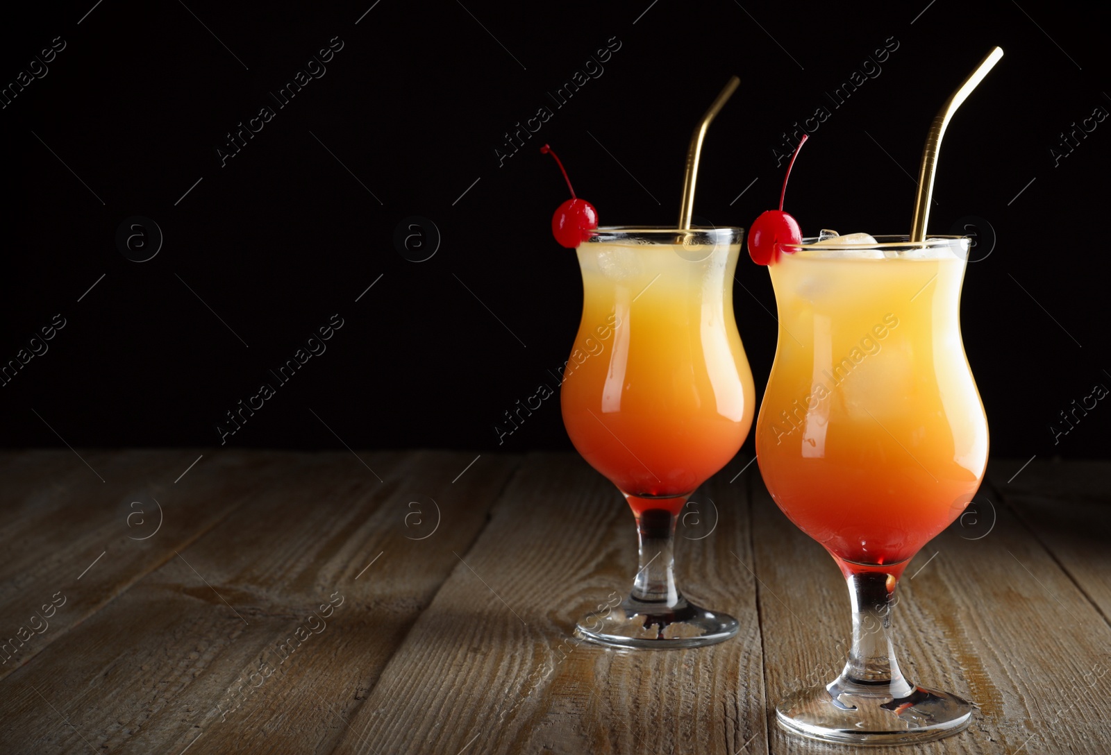 Photo of Just made appetizing cocktails Sex on the Beach, black background. Space for text