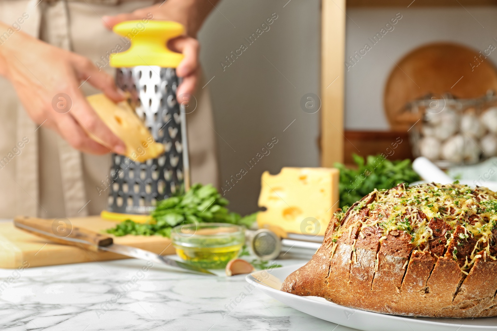 Photo of Tasty homemade garlic bread with cheese  and blurred woman on background. Space for text