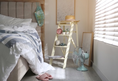 Photo of Decorative ladder with different stuff in stylish bedroom. Idea for interior design