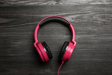 Stylish headphones on wooden background, top view