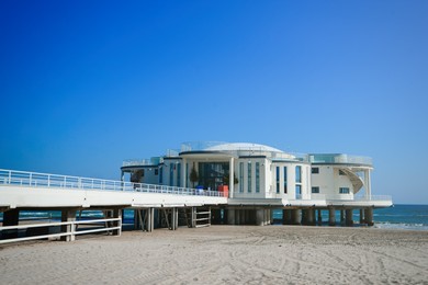 View of white rotonda and pier on sea shore