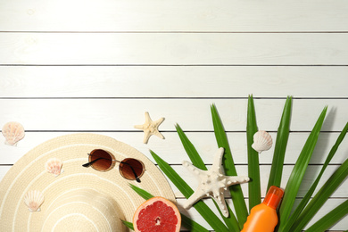 Photo of Flat lay composition with grapefruit and beach objects on white wooden background. Space for text