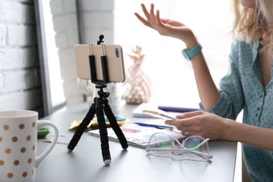 Photo of Female blogger recording video at table