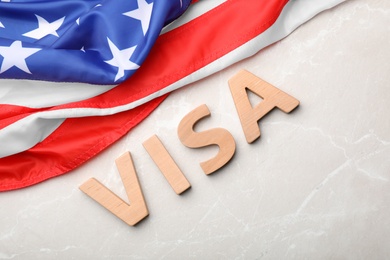 Photo of Flat lay composition with word VISA and flag of USA on gray background