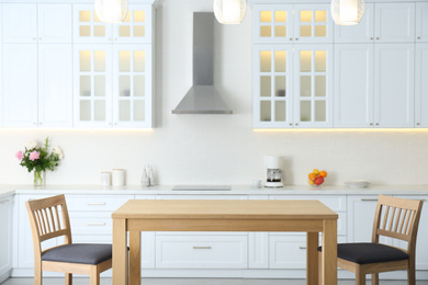 Photo of Wooden table with chairs in modern kitchen interior