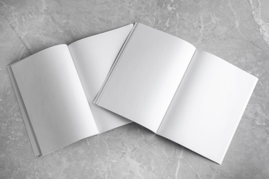 Photo of Blank open books on light grey marble background, top view. Mock up for design