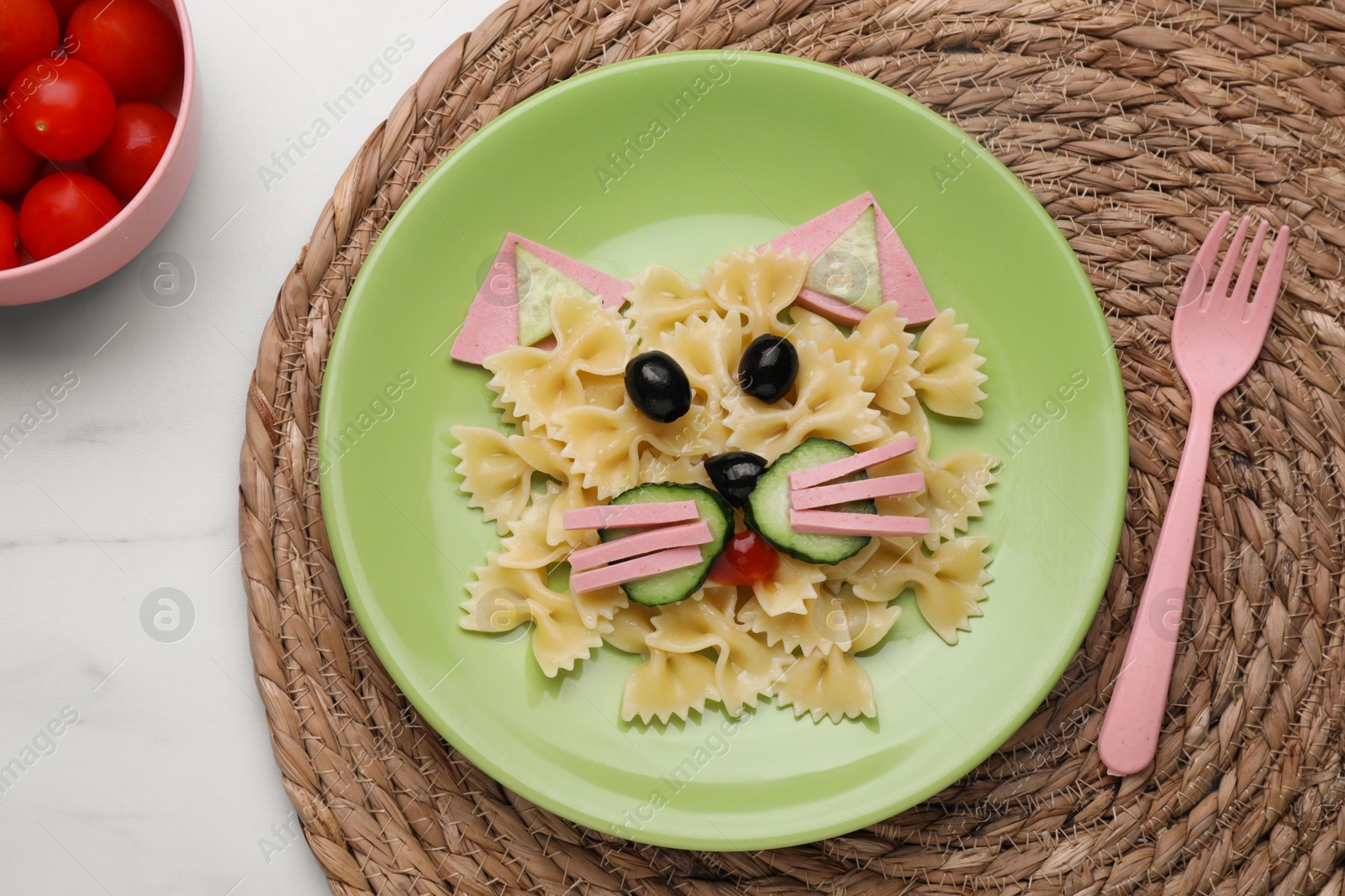 Photo of Creative serving for kids. Plate with cute cat made of tasty pasta, vegetables and sausage on table, flat lay