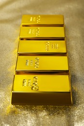 Many gold bars on shiny fabric, closeup