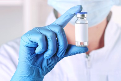 Image of Laboratory worker holding glass vial with medication in hospital, closeup
