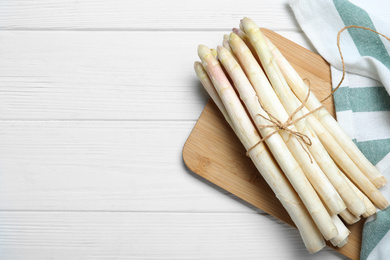 Photo of Fresh white asparagus on wooden table, top view. Space for text