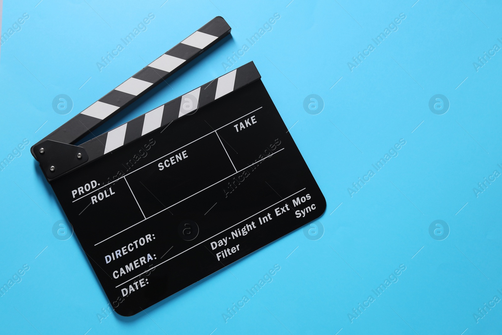 Photo of Clapperboard on light blue background, top view. Space for text