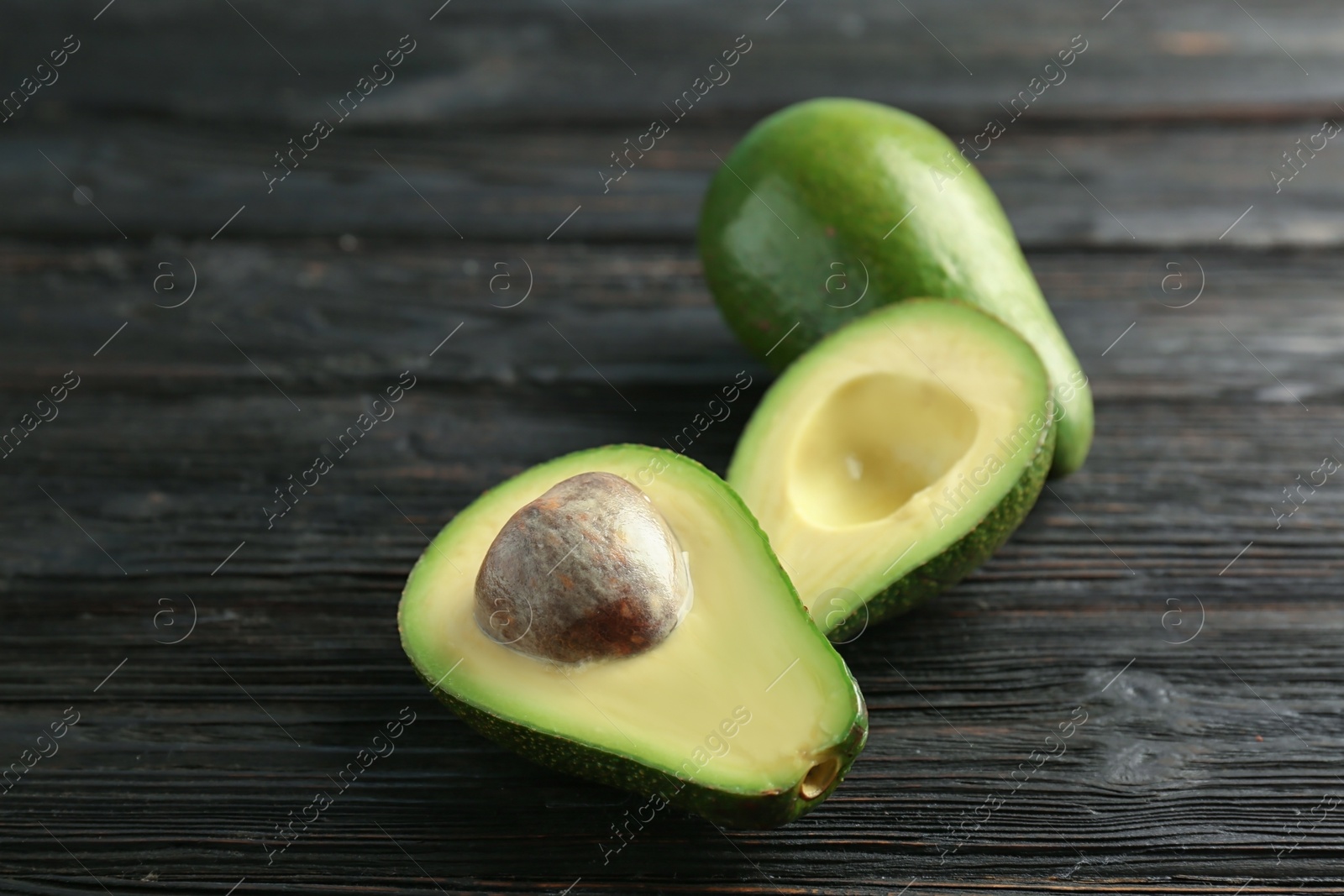 Photo of Tasty ripe green avocados on wooden background