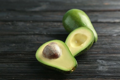 Photo of Tasty ripe green avocados on wooden background