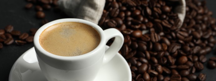 Image of Cup of aromatic coffee and beans on grey table, space for text. Banner design