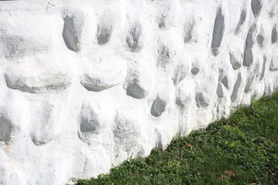 Photo of White stone wall of building near green grass outdoors. Exterior design
