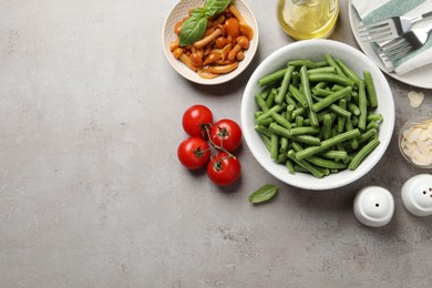 Photo of Fresh green beans and other ingredients on grey table, flat lay. Space for text