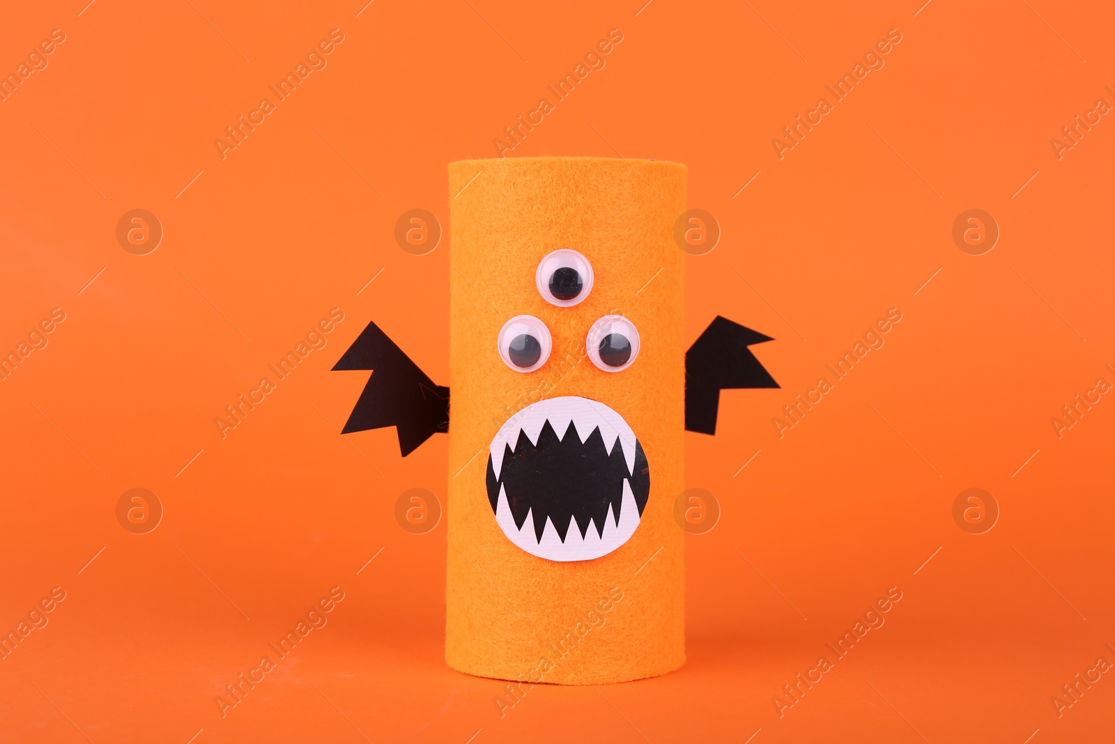 Photo of Spooky monster on orange background. Handmade Halloween decoration