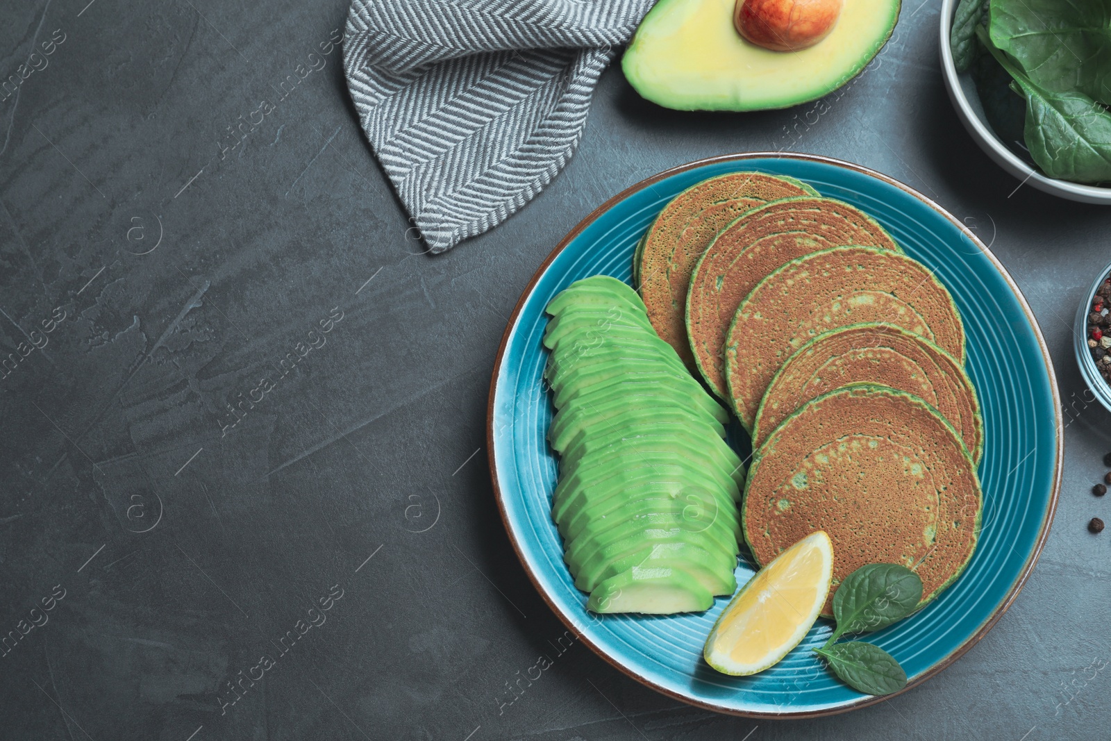 Photo of Tasty spinach pancakes served on grey table, flat lay. Space for text