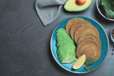 Tasty spinach pancakes served on grey table, flat lay. Space for text