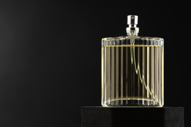 Luxury men`s perfume in bottle against dark background, space for text