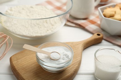 Baking powder and sugar on white wooden table, closeup