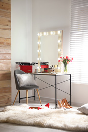 Dressing table and mirror with lamps in stylish room interior