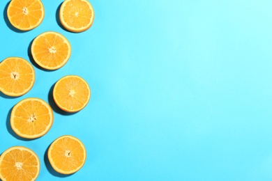 Photo of Flat lay composition with fresh ripe oranges on turquoise background. Space for text