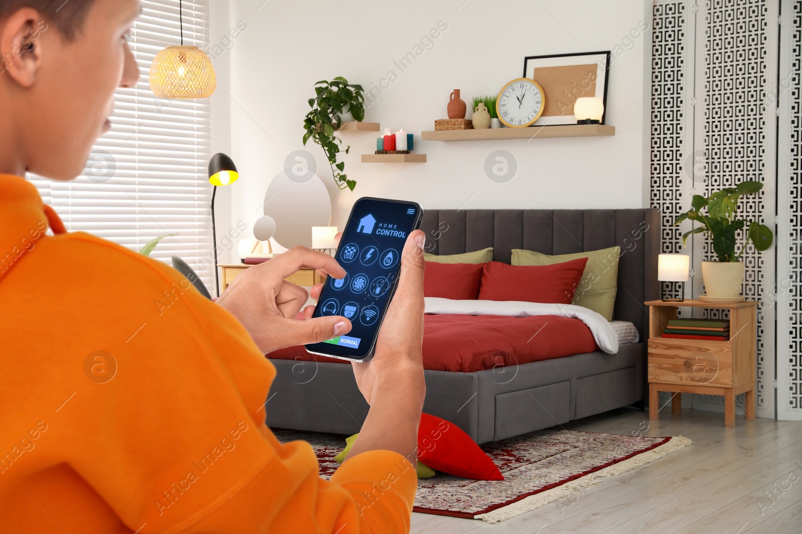 Image of Man using smart home control system via application on mobile phone indoors, closeup