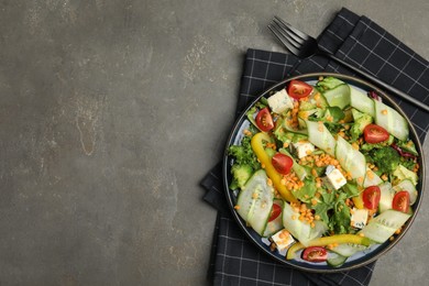 Photo of Delicious salad with lentils, vegetables and cheese served on grey table, top view. Space for text