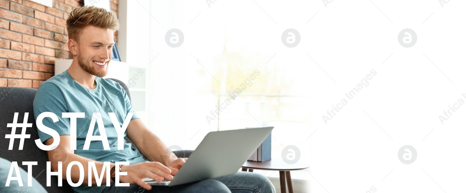 Image of Hashtag Stay At Home - protective measure during coronavirus pandemic, banner design. Young man working with laptop in living room