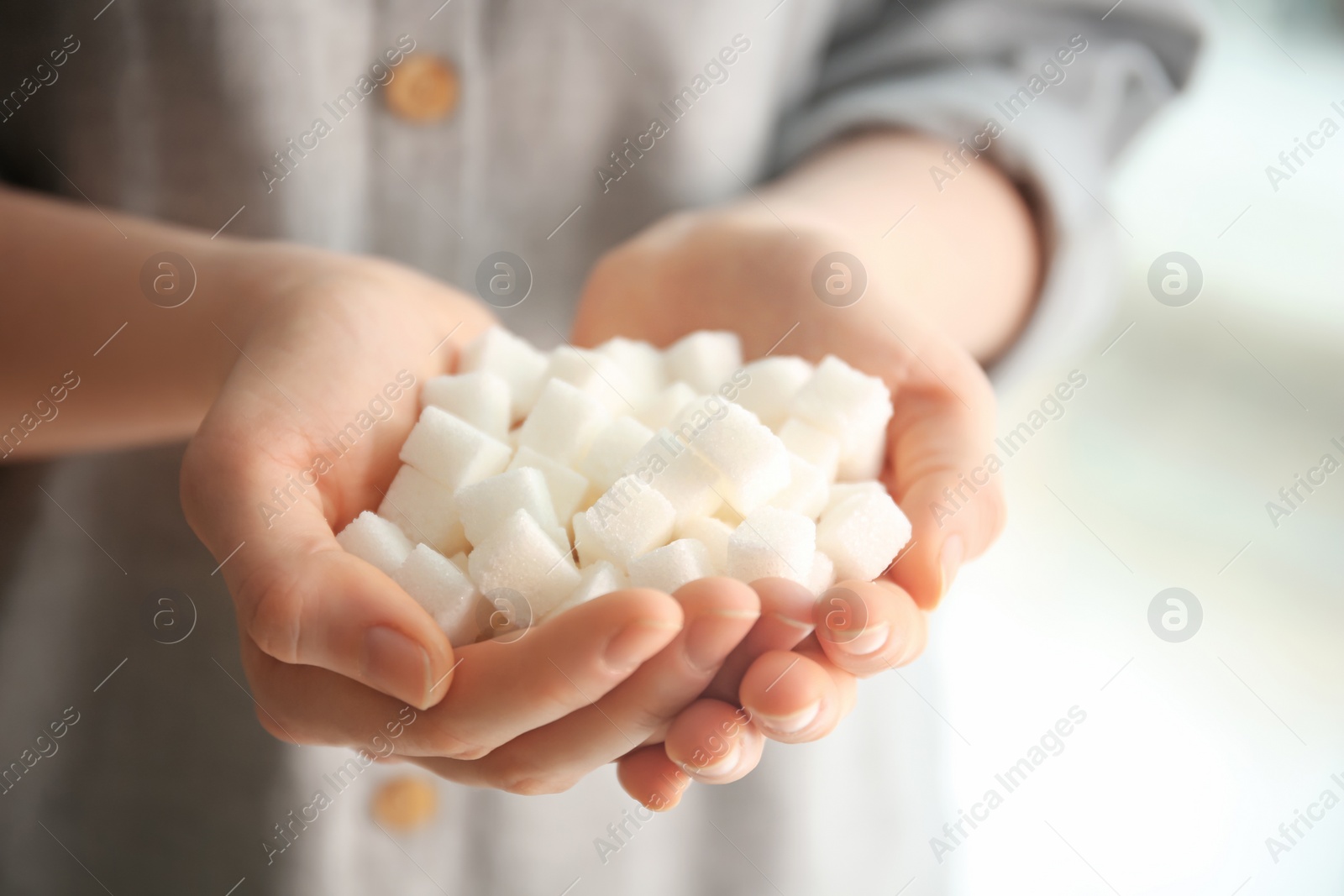 Photo of Woman holding sugar cubes, closeup