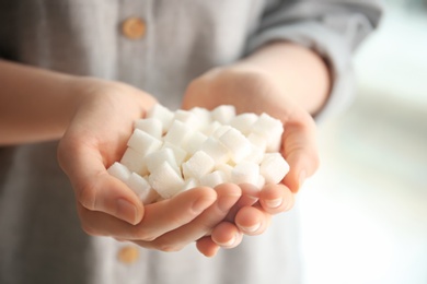 Woman holding sugar cubes, closeup