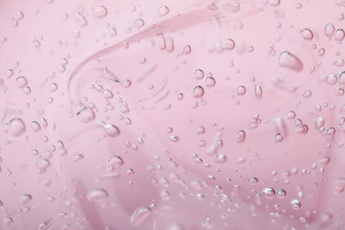 Photo of Pure transparent cosmetic gel on pink background, closeup