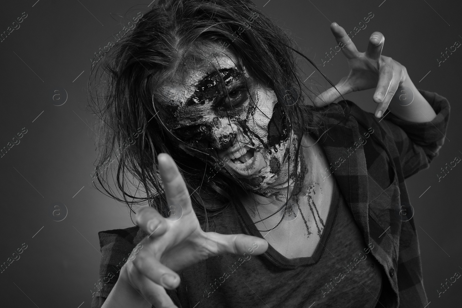 Photo of Scary zombie on dark background, black and white effect. Halloween monster