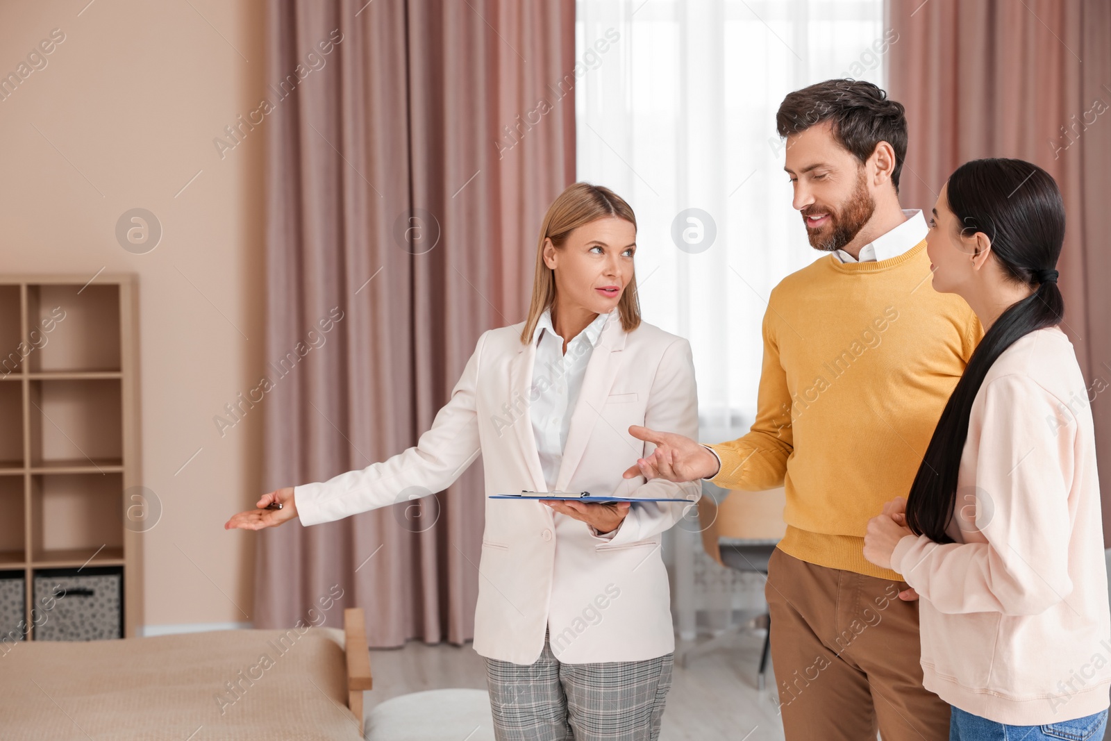 Photo of Real estate agent working with couple in new apartment