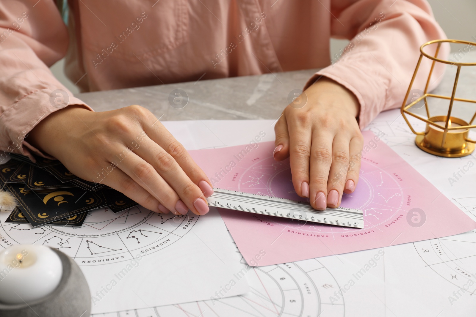 Photo of Astrologer using zodiac wheel for fate forecast at table, closeup. Fortune telling