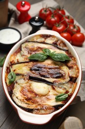 Photo of Delicious eggplant lasagna in baking dish on wooden table